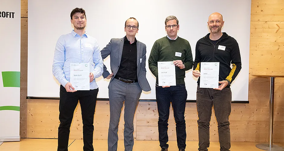 Eine Gruppe von 4 Männern unterschiedlichen Alters mit Abschlußzertifikaten auf einer Bühe